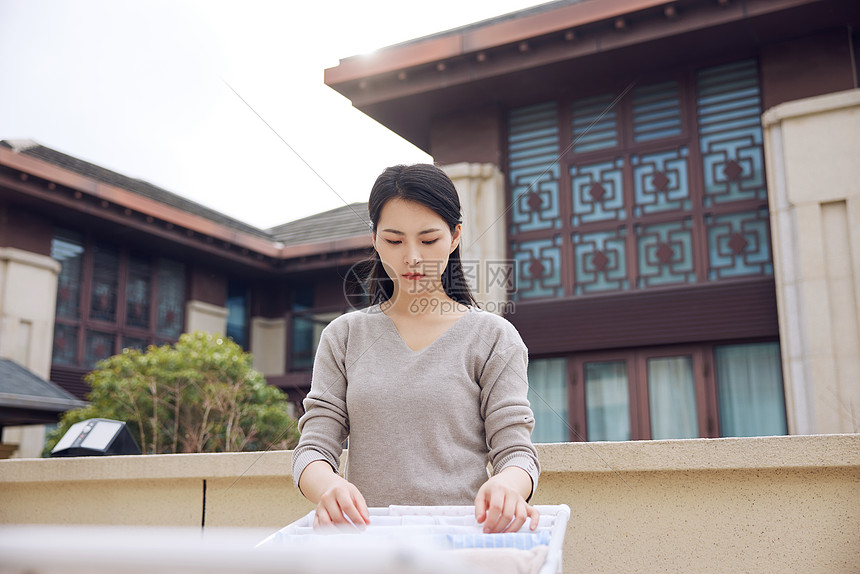 室外晾衣服的女性形象图片