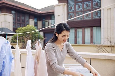 在室外晾晒衣服的女性高清图片