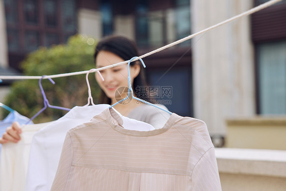 户外晾晒衣服的女性形象图片