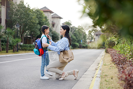 上班女孩妈妈送女儿出门上学背景