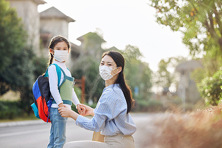 小孩戴口罩戴口罩的妈妈送女儿上学背景