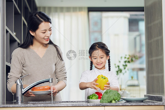 在厨房一起洗菜的母女图片