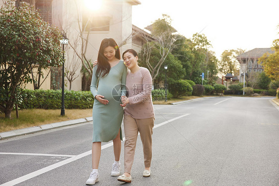 母亲陪怀孕的女儿外出散步休息图片