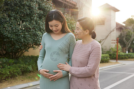 母亲陪怀孕的女儿外出散步图片