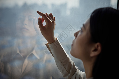 窗边写字的抑郁女性形象图片素材