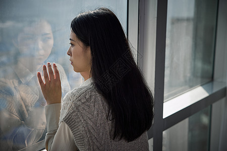 独自在家看向窗外的抑郁女性高清图片