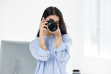单反相机镜头青年女摄影师手拿相机拍摄形象背景