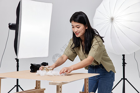相机拍摄青年女摄影师整理静物台背景