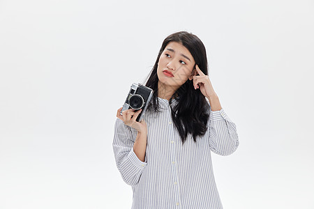 活力搞怪女青年手拿胶片相机的青年女性面露苦恼背景