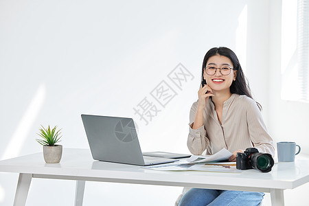 电脑前工作的青年女摄影师背景图片