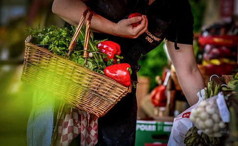 食材采购一名妇女提着菜篮在菜市场采购蔬菜xinxian背景