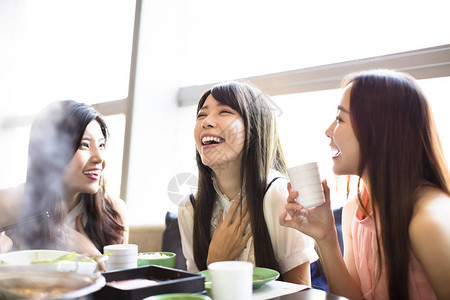 快乐的年轻妇女组吃火锅图片