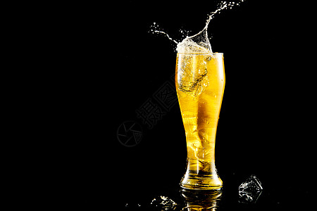 冰块掉落在啤酒杯里溅起水花背景
