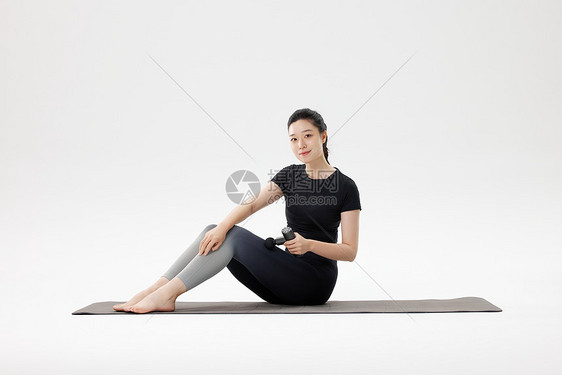 健身女性用筋膜枪放松肌肉图片