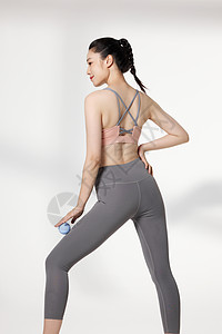 在健身后使用器材放松肌肉的女性高清图片