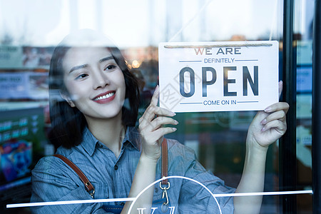 英文标志咖啡店的女服务员挂营业标志背景