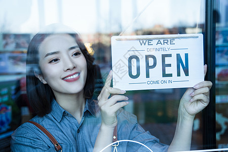 营业中咖啡店的女服务员挂营业标志背景