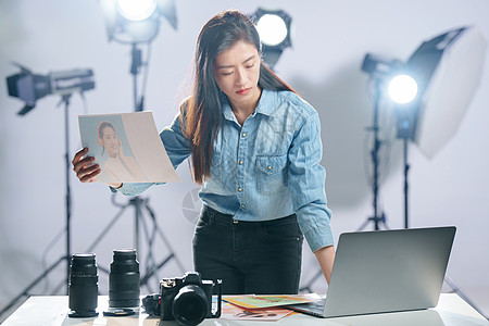 相机摄影在工作室里的青年女摄影师背景