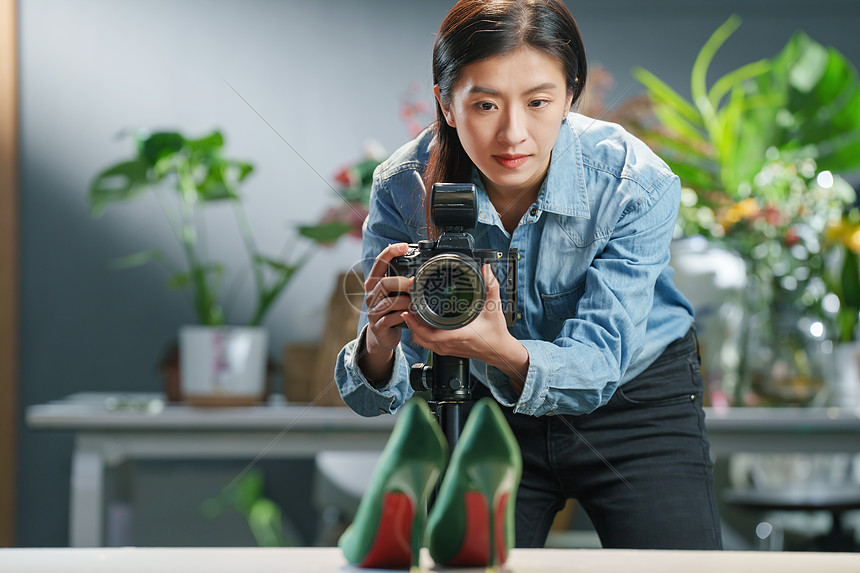 在工作室里拍照的青年女摄影师图片