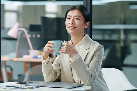 服务客户青年商务女士坐在办公室里喝水背景