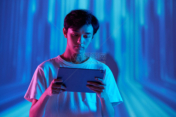 虚拟背景下看平板电脑的男青年图片