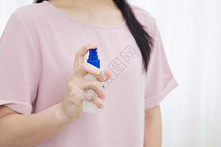 居家女性使用酒精喷雾消毒特写图片