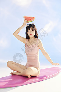 泳装美女坐在冲浪板上图片