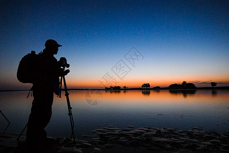 摄影师在河岸边等待日出高清图片