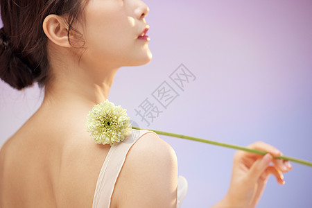 美容美女美女手拿花卉特写背景