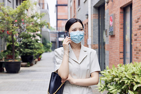 戴口罩的商务女青年室外打电话高清图片