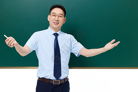 中年教授站在黑板前授课图片