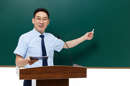 老师站在讲台上男教授手拿粉笔站在讲台上背景