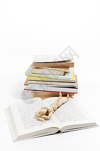创意木头人偶躺在书本上图片