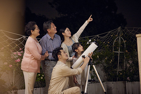 一家人中秋节陪小女孩用望远镜赏月背景图片