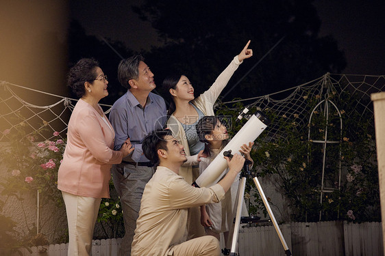 一家人中秋节陪小女孩用望远镜赏月图片