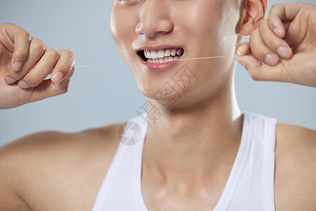 年轻男性使用牙线清洁牙齿图片