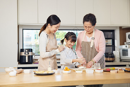 家人一起做饭祖孙三代人中秋节一起制作月饼背景