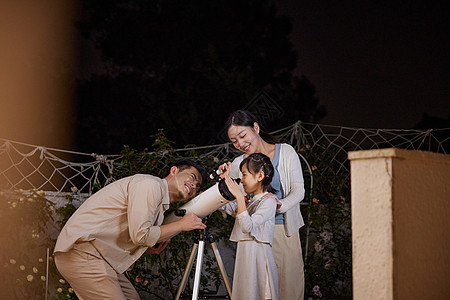 中秋节用望远镜赏月的一家人图片