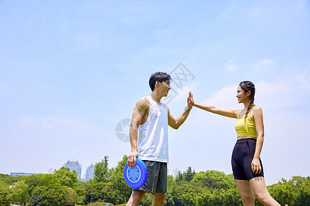 年轻男女玩飞盘击掌图片