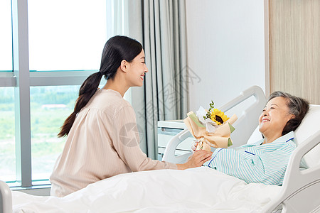 女性手拿花束探望生病住院的老人图片