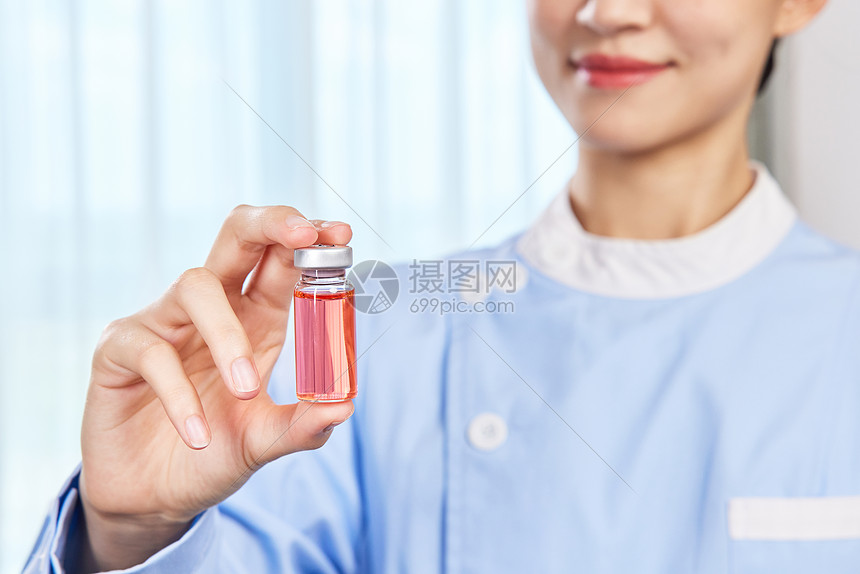 女护士手拿疫苗针剂特写图片