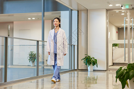 医院建筑走在医院走廊的女医生背景