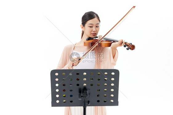 看乐谱拉小提琴的青年女性图片