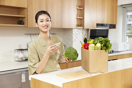 青年女性居家线上团购蔬菜图片