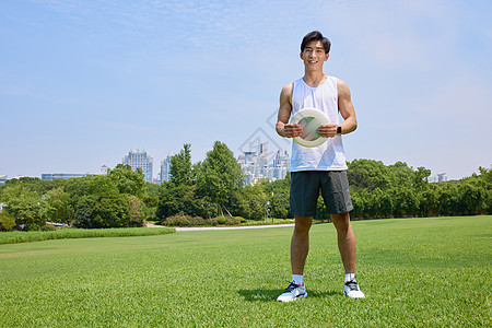 城市草坪男青年在户外玩极限飞盘背景