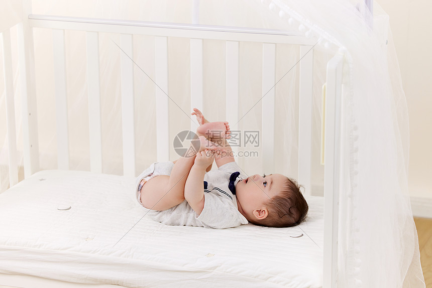 在婴儿床上玩耍的可爱宝贝图片
