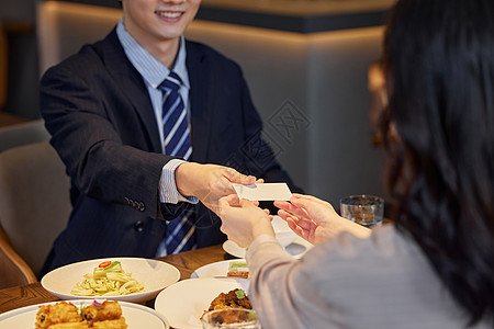 酒店餐厅生意合作伙伴递名片特写图片