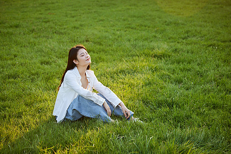 小清新美女初秋在草坪上休闲的年轻女性背景