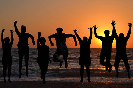 一群人在海滩上跳跃的剪影图片