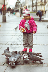 小女孩在街上喂鸽子图片